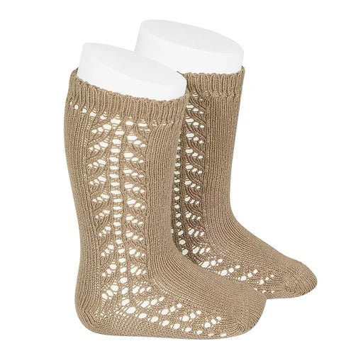 Pair of beige knitted socks with a lace pattern on a white background